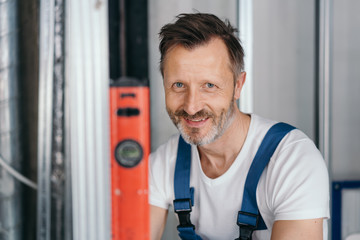Smiling happy builder holding a spirit level