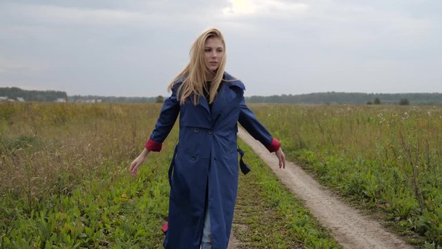 a young woman goes on a field road