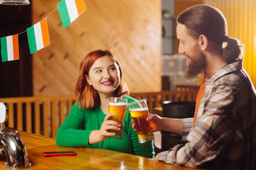 Woman wearing green shirt drinking beer with her new friend