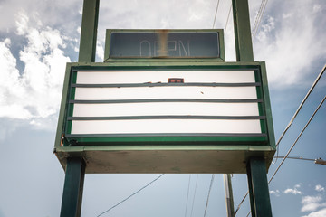 An old, dilapitated and empty changeable letter sign board on a street.