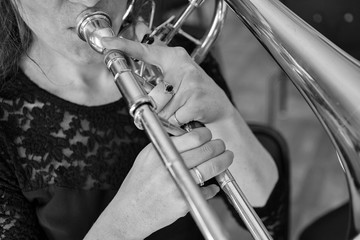 Hands of a girl playing the trombone Black and white image