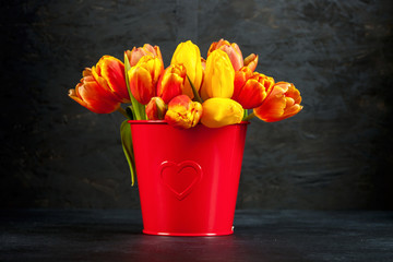 Bouquet of tulips in pot on a dark background. Flowers background. Spring concept
