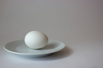 White chicken egg on plate