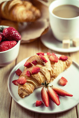 Croissant with cream cheese, strawberries for breakfast