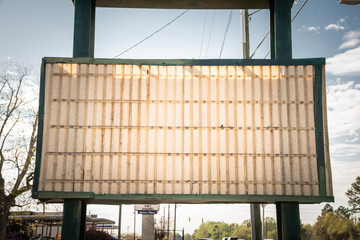 An old, dilapitated and empty changeable letter sign board on a street.