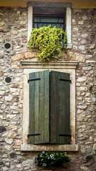 Fototapeta na wymiar Window behind the wooden shutters in Tuscany, Italy