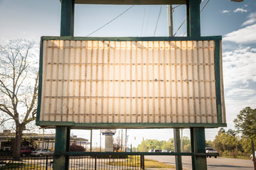 An old, dilapitated and empty changeable letter sign board on a street.