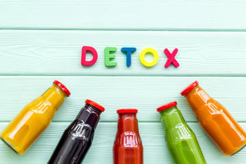 fresh organic juices in bottles for detox diet on green wooden background top view mock-up