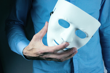 man holds mask in his hand