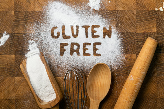 Gluten free baking concept - text with kitchen utencils, eggs, milk, butter, top view