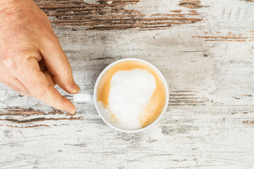 Café con leche con mano de hombre vista de arriba