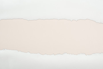 Naklejka premium ripped white textured paper with copy space on ivory background