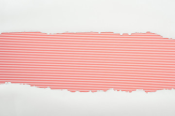 ripped white textured paper with copy space on red striped background