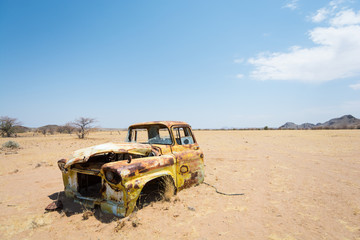 Car left a long time ago, dented and rusted, in absolute solitude of Damaraland, Namibia, Africa.