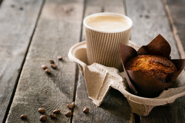 Coffee to go with muffin on wood background, copy space - Powered by Adobe