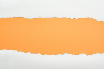 ragged white textured paper with copy space on orange background