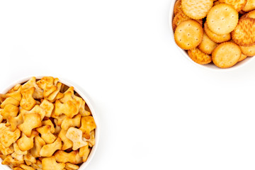 Salty crackers and goldfishes, shot from the top on a white background with copy space. Party snacks banner with a place for text