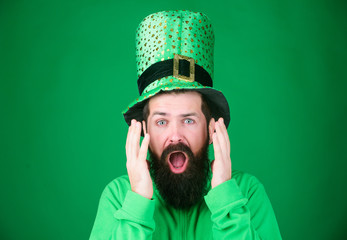 Feeling shocked. Bearded man keeping mouth open while celebrating saint patricks day. Hipster in...