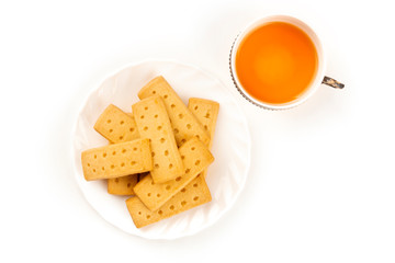 A closeup photo of Scottish shortbread butter cookies, shot from the top on a white background with a cup of tea and copy space