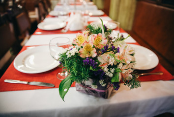 Wedding flowers standing on the table. Decoration details. Reception at the restaurant.