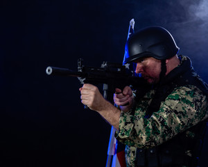 Soldier holding assault rifle in smoky haze