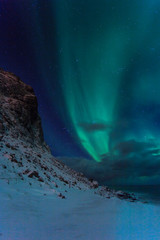 Northern lights at night against the backdrop of beautiful mountains in Norway