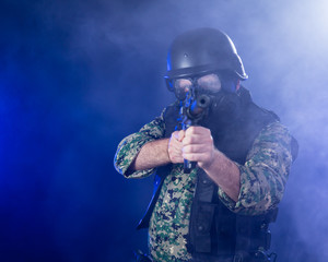 Soldier holding assault rifle in smoky haze