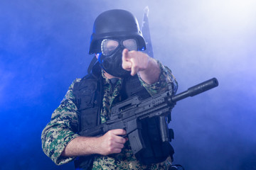 Soldier holding assault rifle in smoky haze