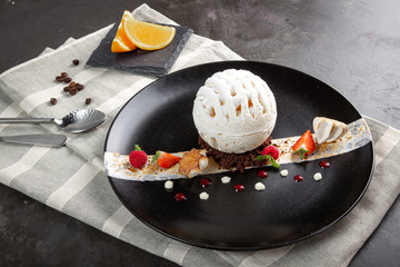 Meringue dessert with raspberries and strawberries in a black plate on a black background