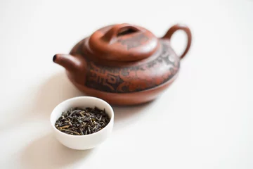 Foto op Aluminium Clay teapot and the white drinking bowl of chinese tea on white background © Vladyslava