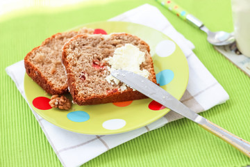 Two piecies Banana bread healthy tasty breakfast Loaf walnuts icing cream cheese Green light plate background Selective focus