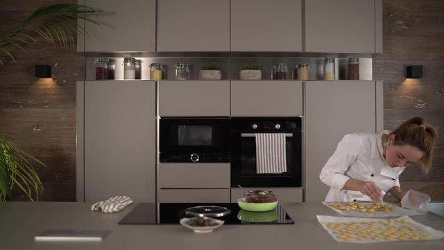 4K food video, woman female cook decorating cookies in modern kitchen