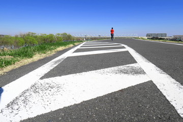 ゼブラゾーンのある春の江戸川土手の道路風景