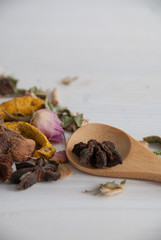 Vertical shot of spices with wooden spoon, white wooden background with copy space