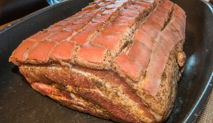 Pork ribs in metal pan, marinated and skin cut into cubes ready for hot oven. 