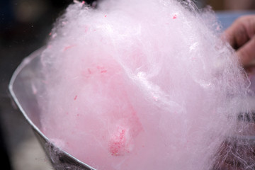 Cotton candy being made out of pink dyed sugar for joyful children. Concept of unhealthy eating, too much sugar. Diabetes.  