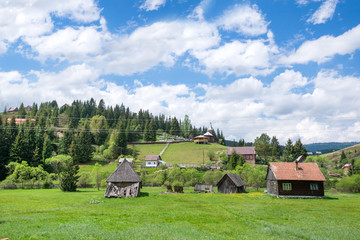 Fototapeta na wymiar Beautiful mountain landscape. Village in the countryside in Romania. Rural scene in sunny summer day