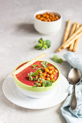 Spring detox beetroot soup with mint, coconut milk and baked chickpeas on a light grey concrete background, copy space. Dieting, clean eating, weight loss, vegetarian food concept.
