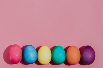 Easter background with Easter eggs. Top view with copy space. multicolored Easter eggs on a pink background
