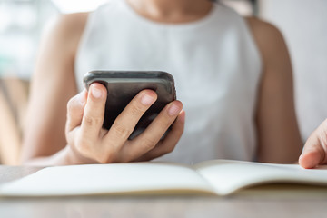 Young Asian Businesswoman using mobile phone in office, woman sitting and hand touching screen on cellphone. Smart business and Technology concepts