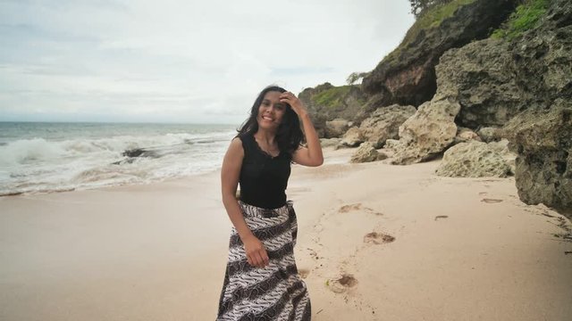 Indonesian girl posing on a beautiful and rocky beach in Bali. Idonezia.