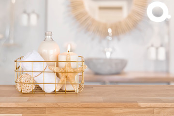 Basket with spa products on wood over blurred bathroom interior