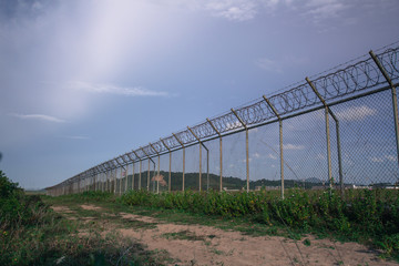 Metal fence wire, War and sky in the background in Phuket Thailand