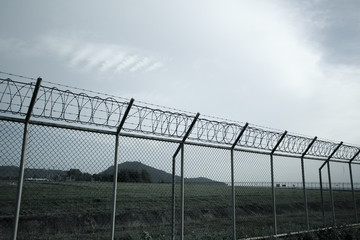 Metal fence wire, War and sky in the background in Phuket Thailand