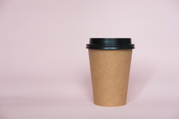Coffee cup on pink paper background. A couple of paper cups of coffee to take away.