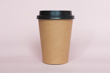 Coffee cup on pink paper background. A couple of paper cups of coffee to take away.