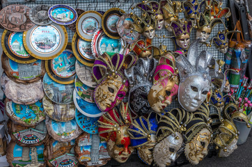 Closeup of a street stand selling souvenirs as carnival masks and plates in Pisa, Italy