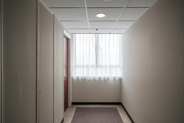 Windows and rooms at the end of the corridor With light from the outside shining through the window with white curtains