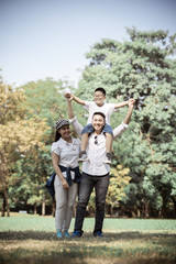 Happy children and parents playing in the park. Concept family relaxation.