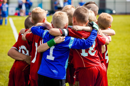Team Sports for Kids. Children Sports Soccer Team. Coach Motivate Soccer Players to Play as a Team. Boys Kids Soccer Football Game. Young Children In Huddle Building Team Spirit. © matimix